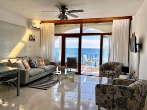 a living room with a couch and a view of the ocean at Pissouri Beach Front Apartments in Pissouri