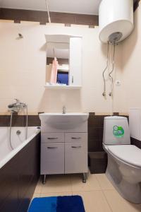 ein Badezimmer mit einem Waschbecken, einem WC und einer Badewanne in der Unterkunft ОК! Советская, 69 №3 in Tomsk