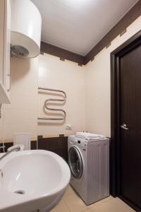 a bathroom with a washing machine next to a sink at ОК! Советская, 69 №3 in Tomsk