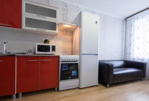 a kitchen with a white refrigerator and a microwave at ОК! Советская, 69 №3 in Tomsk