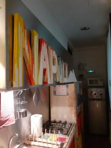 ナポリにあるChiaia Street Holidayのキッチン(コンロ付)、カラフルなアートが飾られたキャビネットが備わります。
