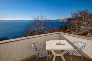 a table and chairs on a balcony with a view of the ocean at Art House in Stara Baška