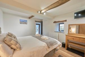 a bedroom with a bed and a dresser and a mirror at Dalecote Barn Bed & Breakfast in Ingleton 