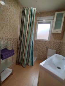 a bathroom with a shower curtain and a sink at Cabañal Port Marina in Valencia