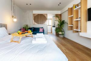 een groot wit bed in een woonkamer met een tafel bij Septa Studios by Skg Apartments in Thessaloniki