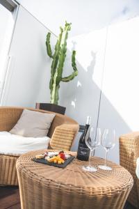 una mesa de mimbre con un plato de comida y copas de vino en Alenti Sitges Hotel, en Sitges