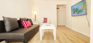 a living room with a couch and a white table at Apple Garden A-2 in London