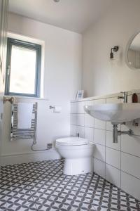 a white bathroom with a toilet and a sink at Kilnside in Uplyme