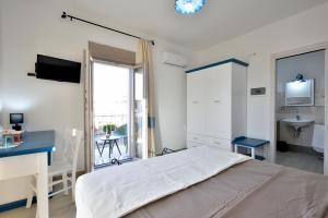 une chambre avec un lit, un bureau et un lavabo dans l'établissement INAH Rooms, à Dorgali
