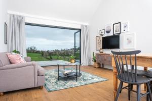 a living room with a couch and a tv at Kilnside in Uplyme
