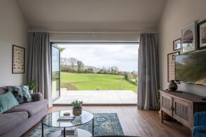 a living room with a large window and a couch at Kilnside in Uplyme