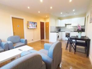 a kitchen and living room with blue chairs and a table at Apple Garden B-4 in London