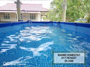a swimming pool with a sign in the water at Toq Abah Villa Pagoh - Mini Cinema , Karaoke , Private Pool , WiFi , NetFlix in Muar
