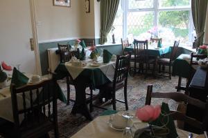 a dining room with tables and chairs and a window at The Belmont in Bridlington