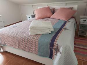 uma cama com um cobertor e duas almofadas em Tabua Village Nature Lovers & Sea #5 em Ribeira Brava