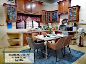 a kitchen with a table and chairs in it at Toq Abah Villa Pagoh - Mini Cinema , Karaoke , Private Pool , WiFi , NetFlix in Muar