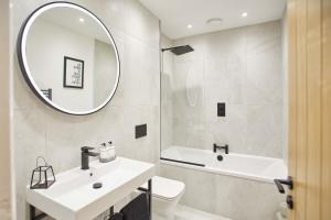 a white bathroom with a sink and a mirror at Host & Stay - Little Acorn Apartment in Whitby