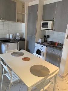 a kitchen with a table and chairs and a microwave at Studio CENTRE CROISETTE in Cannes