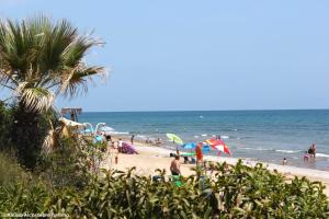 a group of people on a beach with umbrellas at Villa Cala Blanca in Alcossebre