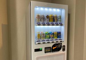 a white refrigerator with drinks in it at Bande Hotel Tenpozan Higashi in Osaka
