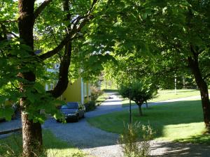 a driveway with a car parked next to a house at Hotel PerOlofGården in Åsbro