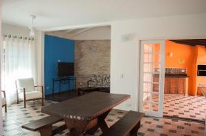 a living room with a table and a dining room at Pousada Pantai Maresias in Maresias