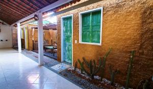 een huis met een groene deur en een patio bij Casa do Sertão - Vila Aju in Aracaju