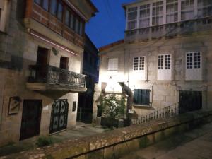 een oud gebouw met een balkon in een straat bij Fonte Zeta in Baiona