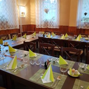 a dining room with tables with yellow napkins on them at Guest House Pod Lesem Merklín in Merklín