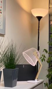 een lamp op een bureau naast een plant bij Hotel Central in Valdepeñas