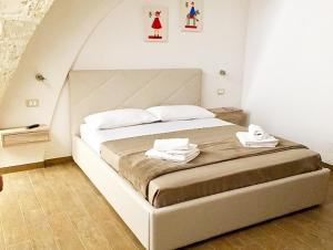 1 dormitorio con 1 cama grande y 2 toallas. en A Quattro di Mazze en Trapani