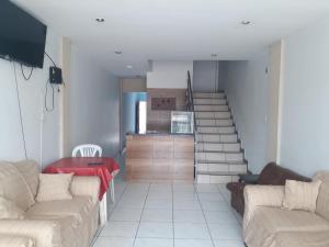 a living room with a couch and a staircase at Alojamiento Oasis in Santa Cruz de la Sierra