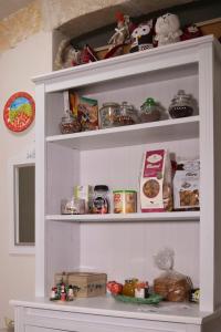 un estante blanco lleno de alimentos y otros artículos en A Casa di Antonella en Vittoria