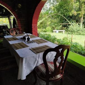 einen Tisch mit einer weißen Tischdecke und zwei Stühlen an einem Tisch in der Unterkunft La Acuarela, Posada de La Monita in Pereira