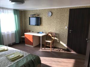 a hotel room with a desk and a tv on the wall at Penzion- Leslav in České Budějovice