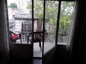 una ventana con una silla que da a un balcón en Aurora familiar, en Montevideo