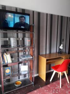 Habitación con TV, escritorio y silla. en Aurora familiar en Montevideo