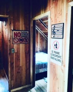 Habitación con cama y letreros en la pared en Hostal Andalue, en Puerto Fuy