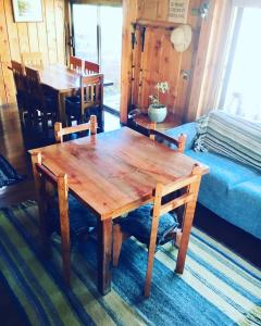 una mesa de madera y sillas en una habitación en Hostal Andalue, en Puerto Fuy