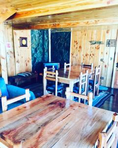 una sala da pranzo con tavolo e sedie in legno di Hostal Andalue a Puerto Fuy