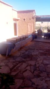 a bed sitting in the middle of a stone patio at Chez Bilal Ait Ben Haddou in Ouarzazate