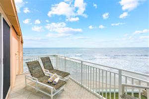 einen Balkon mit einem Stuhl und Meerblick in der Unterkunft Paradise Beach Club - Oceanfront and Penthouse in Satellite Beach