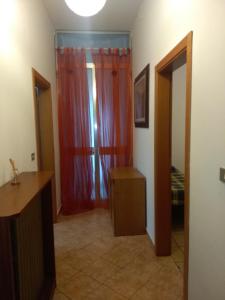 a room with a red curtain and a room with a bed at Maria in Rimini