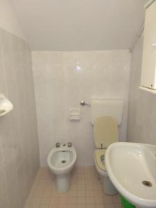 a white bathroom with a toilet and a sink at Maria in Rimini
