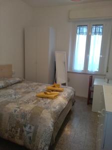 una camera da letto con un letto con asciugamani gialli di Maria a Rimini