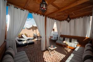 - un salon avec des rideaux blancs et un canapé dans l'établissement Riad des trois palais, à Marrakech