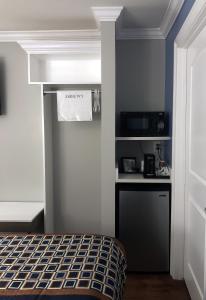 Kleines Zimmer mit einem Bett und einer Mikrowelle. in der Unterkunft Destin Inn & Suites in Destin