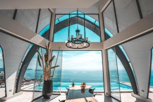 Cette chambre est dotée de grandes fenêtres et d'un lustre. dans l'établissement Sky Dream Villa Award Winning Sea View Villa, à Chaweng Noi Beach