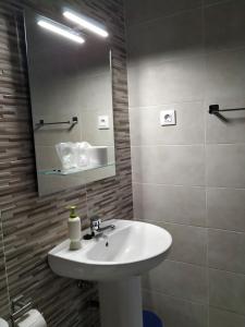 y baño con lavabo blanco y espejo. en Pension Cuatro Torres en Madrid