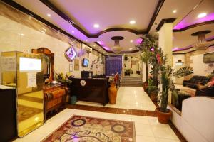um quarto com um átrio com luzes roxas e um quarto com um átrio em Al Eairy Apartments - Al-Damam 2 em Dammam